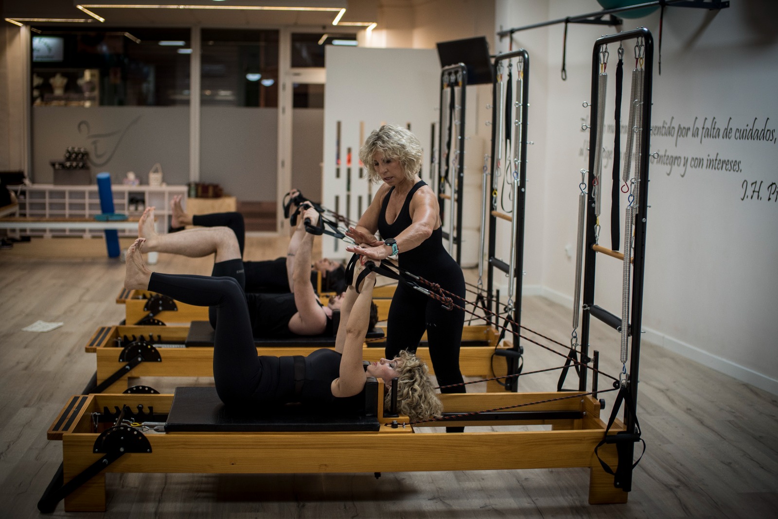 Lola Aguilera corrigiendo a alumnas durante una clase en reformer